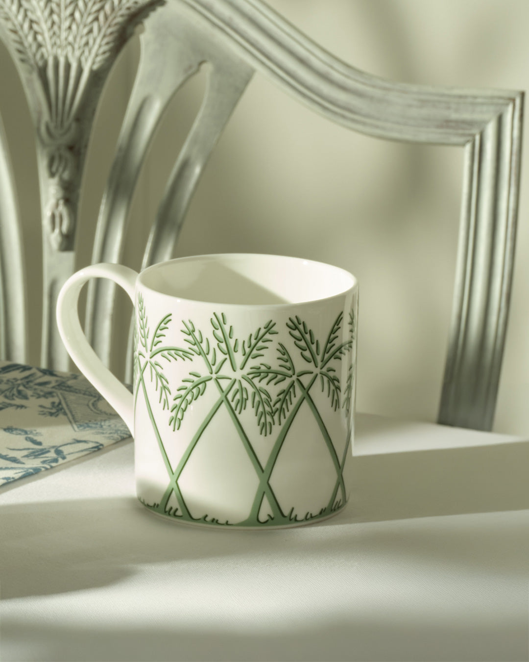 Fine bone china mug and dessert plate in Palms Sage Green by Lotty B Mustique, elegant English tea setting.