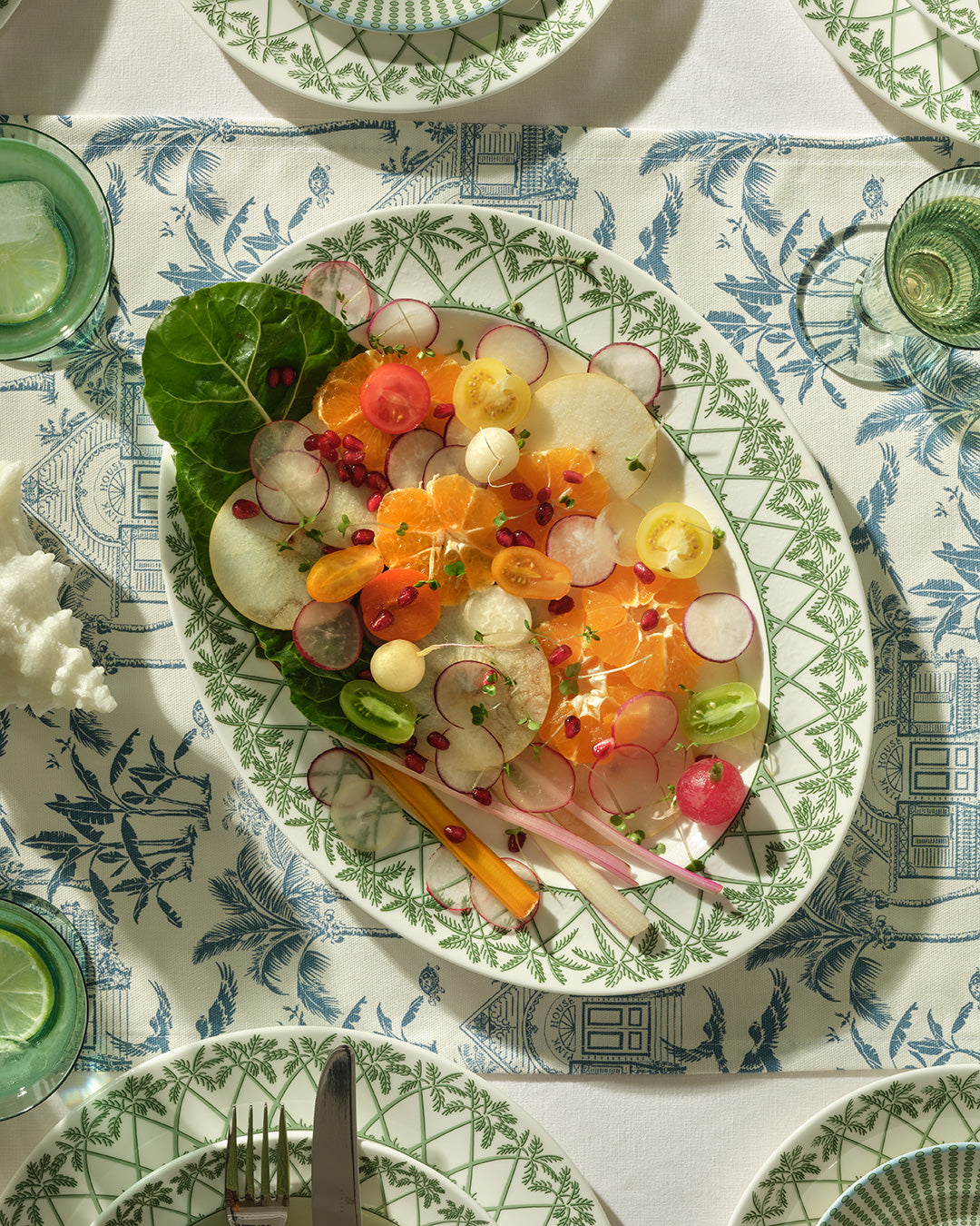 Luxury island dining table with fine bone china oval platter in Palms Sage Green, handmade in England for Pink House Mustique.