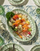 Luxury island dining table with fine bone china oval platter in Palms Sage Green, handmade in England for Pink House Mustique.