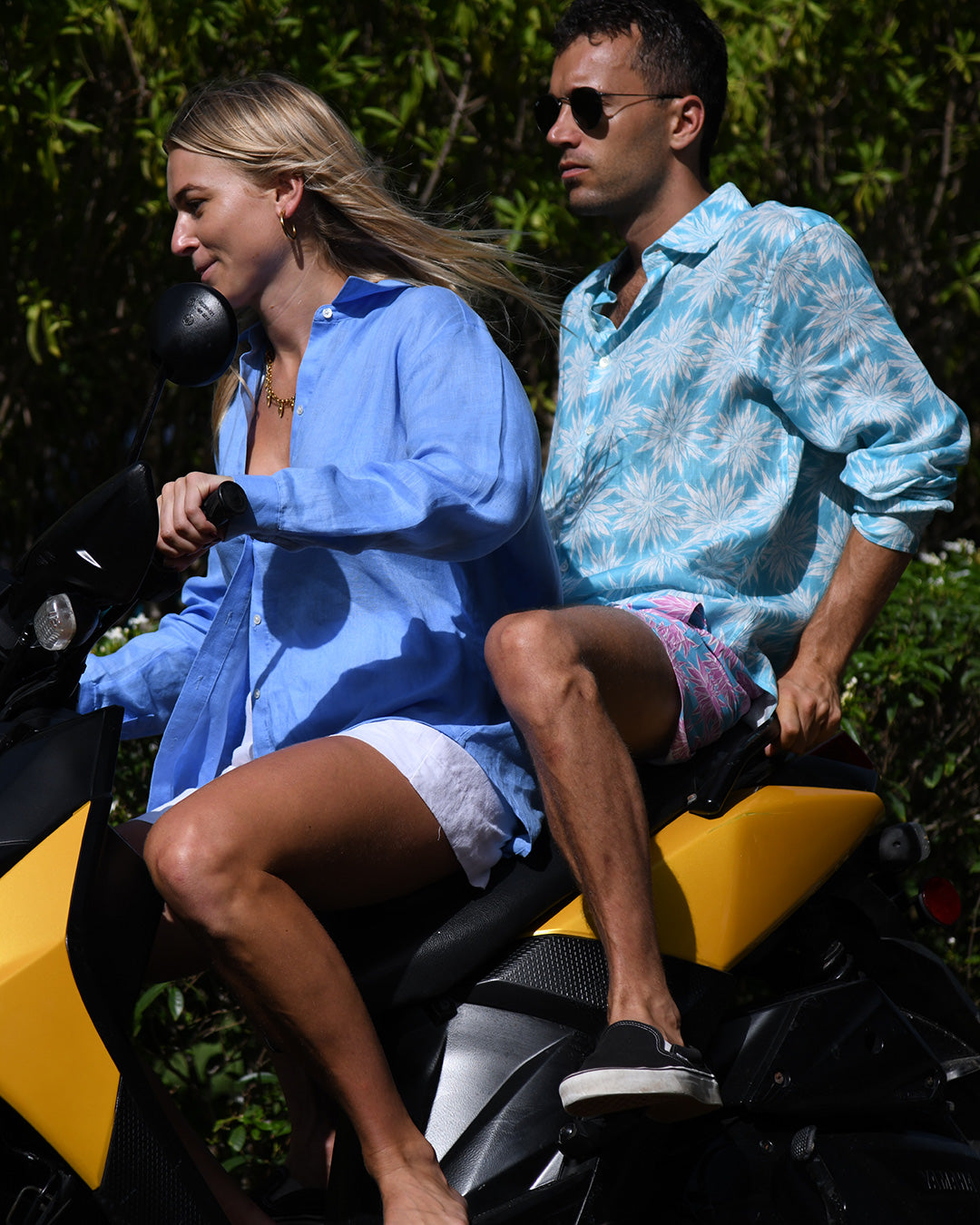 Island lifestyle photo – men’s Agave turquoise linen shirt and women’s French blue Anastasia shirt, Pink House Mustique.