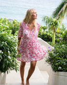 Constance wearing Pink House pure silk crepe-de-Chine tiered dress in Parrot Pink – lightweight island resortwear for summer style.