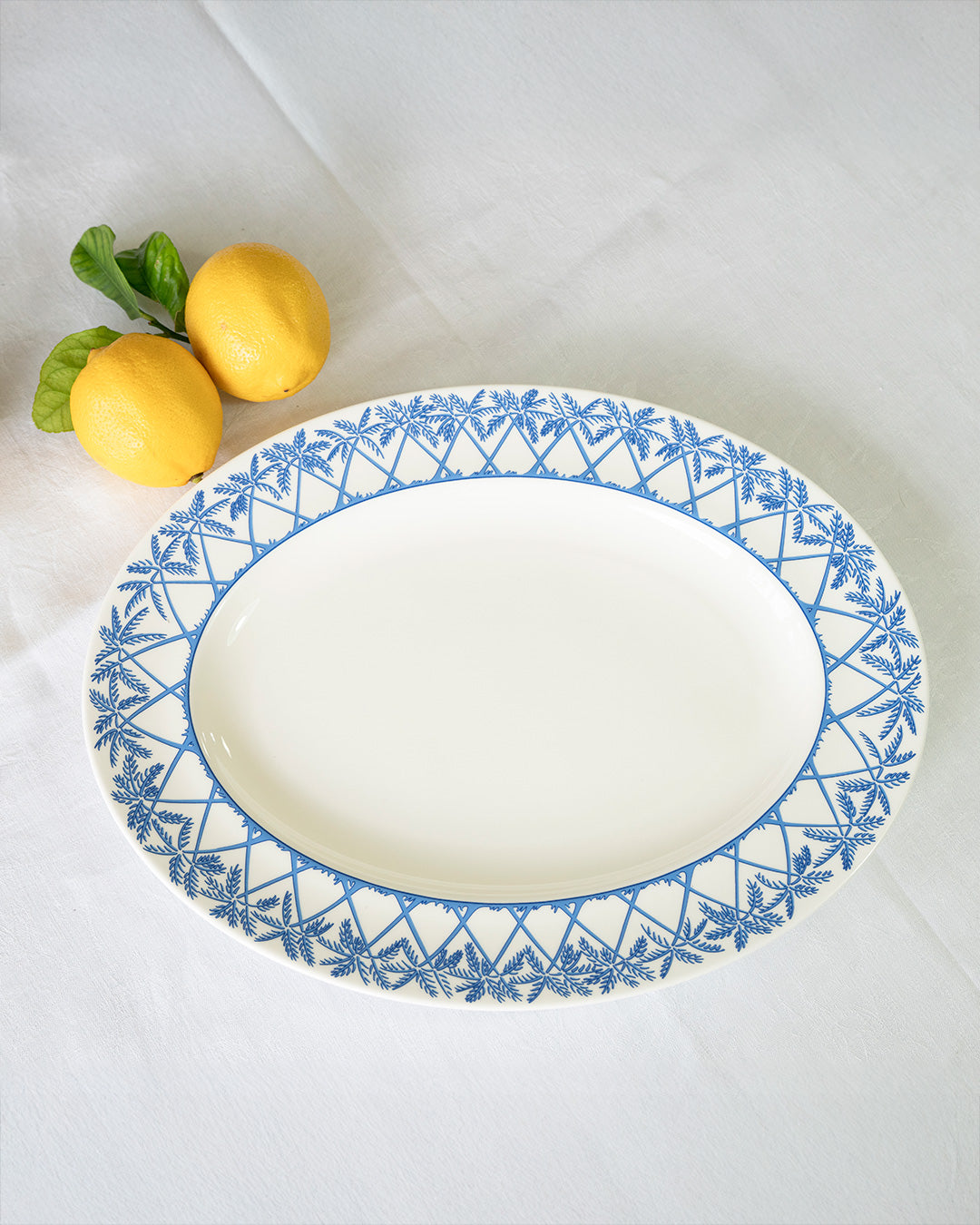 Fine bone china Palms Azure blue oval platter by Lotty B Mustique luxury dinnerware with fresh lemons