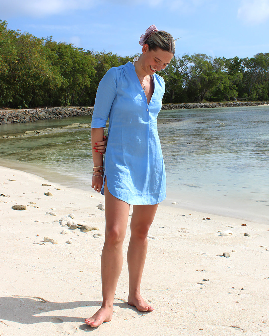 Woman wearing French Blue Linen Decima Dress by the sea – lightweight beach cover-up by Pink House Mustique