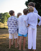 Unisex kids linen shirts in monkey and palms print, plum navy and green, styled for summer family holidays