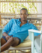 Relaxing on vacation in a mens bright turquoise linen shirt by Pink House Mustique