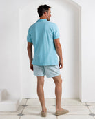 Luxury turquoise polo shirt and Coral Stone Aqua swim shorts, Pink House Mustique men’s resort outfit.