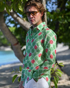 Man wearing Watermelon Green linen shirt and sunglasses by the beach in Mustique