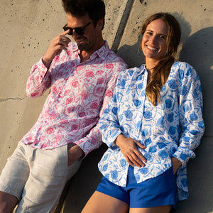 man and woman in matching shirts leaning against a wall