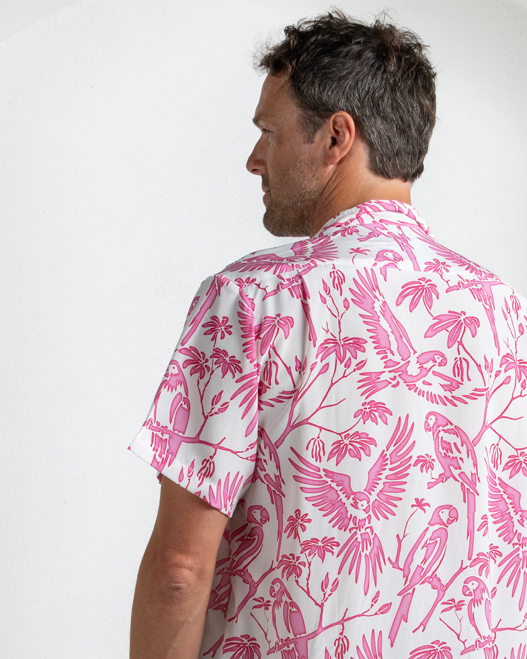 Back view of silk shirt in parrot pink print – breathable designer resortwear for men by Pink House Mustique