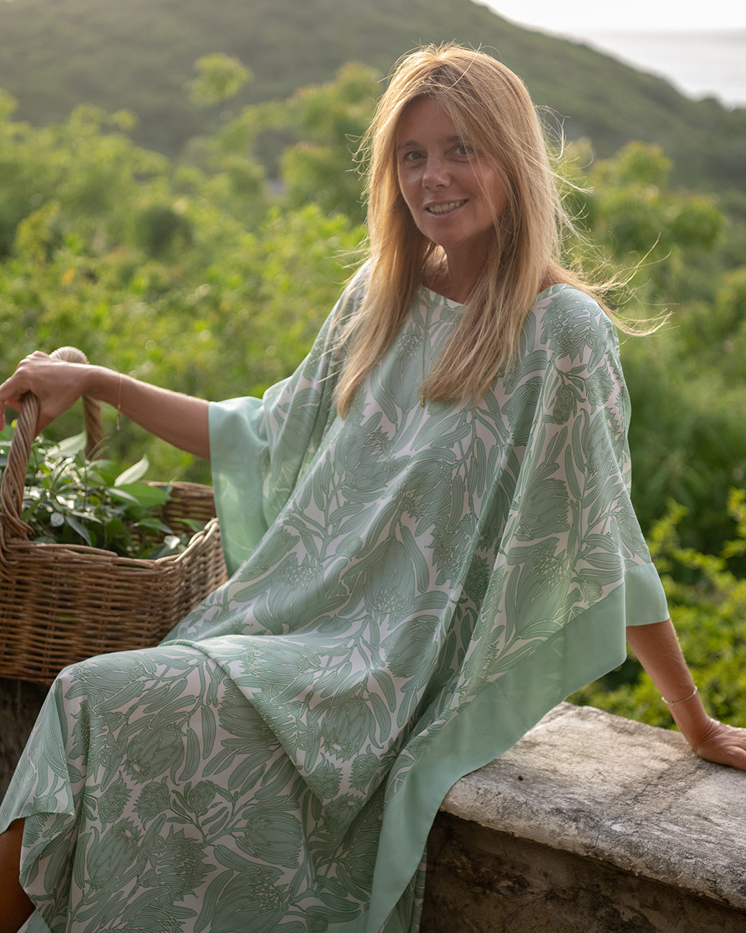 Samantha silk kaftan in Protea Sage Green White worn in a tropical Caribbean garden setting