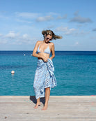 Model wearing luxury Lotty B silk Blue Pineapple sarong and bikini set by the sea on Mustique’s Cotton House pier.