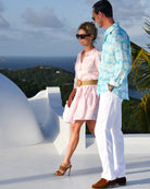 Couple wearing Resort 2026 Agave prints – men’s turquoise linen shirt and women’s pink Amy tiered dress by Pink House Mustique