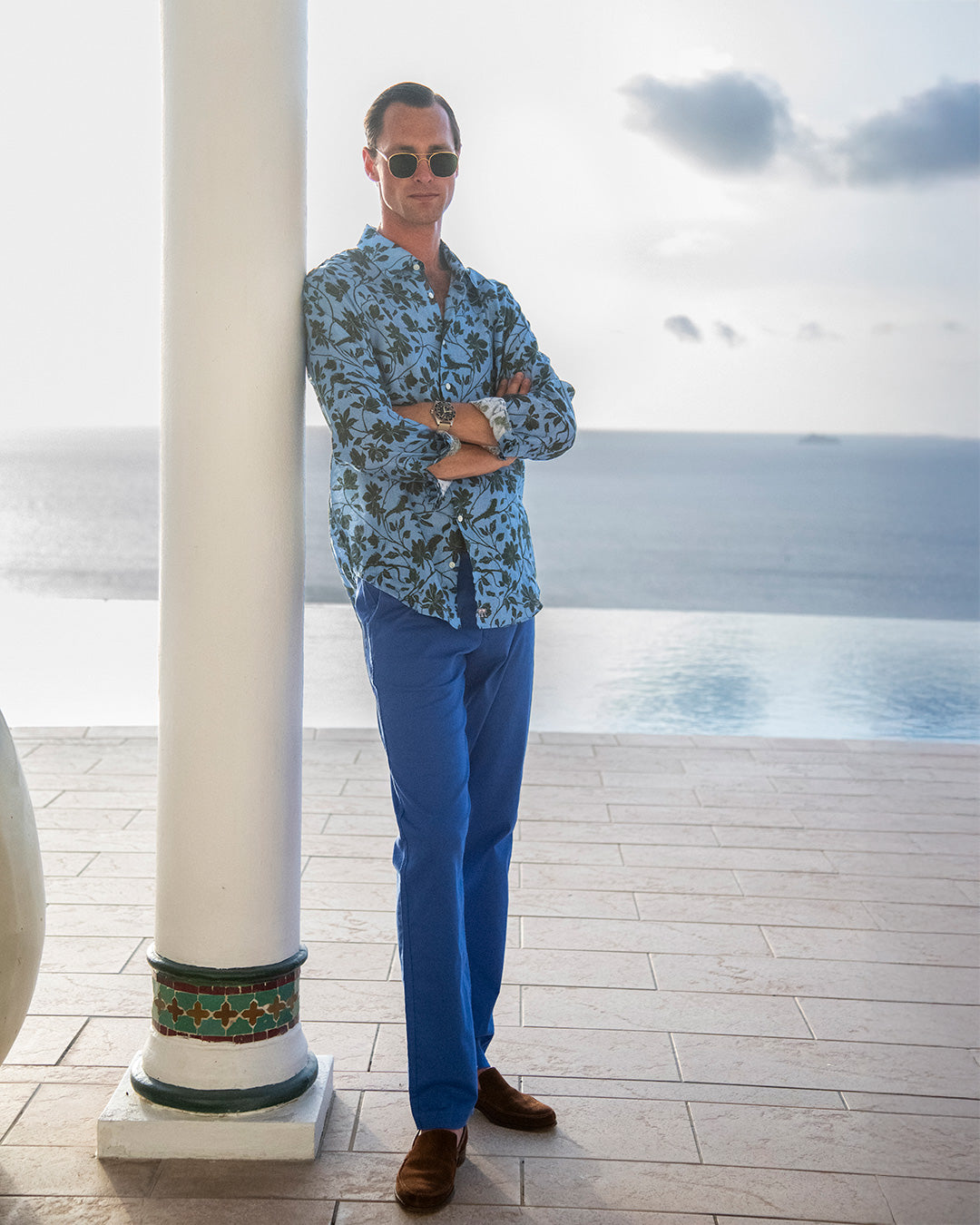 Men’s Iguana Blue & Spruce linen shirt at Toucan Hill, Mustique — luxury island style with blue linen trousers.