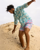 Men’s turquoise blue Agave linen shirt with matching pink and turquoise swim shorts by Pink House Mustique.