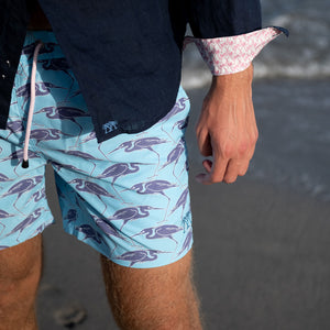 Sustainable Mens holiday shorts in blue Egret bird print Cotton House pier, Mustique