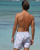 Back view of Pink House Mustique Mermaid Pink Blue swim shorts worn on the beach at Lagoon Bay Mustique