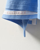 Close-up of the Pink House Mustique men's mid blue cotton polo shirt with signature Mustique neck tape detail