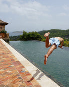 Man diving into a pool in Mustique Mule Multi swim shorts on Mustique