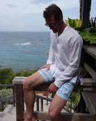 Men’s Mustique Mule red swim shorts with white linen shirt on Mustique