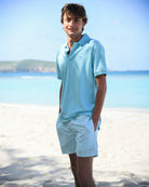 Men’s Coral Stone Aqua swim trunks and cotton polo shirt by Pink House Mustique, luxury beachwear look.