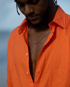 Close-up of Pink House men’s orange linen shirt showing soft texture and open neckline, breathable luxury summer fabric