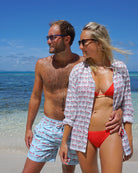 Mustique Mule red men’s swim shorts worn on the beach in Mustique