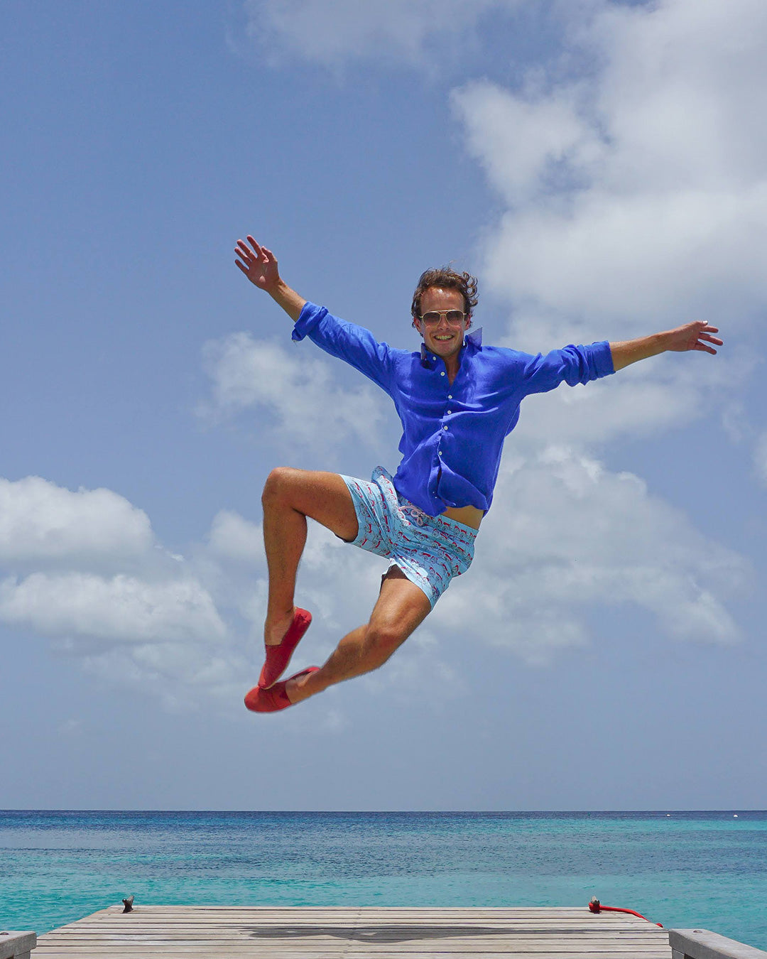 Men’s Mustique Mule red swim shorts worn by the sea on Mustique