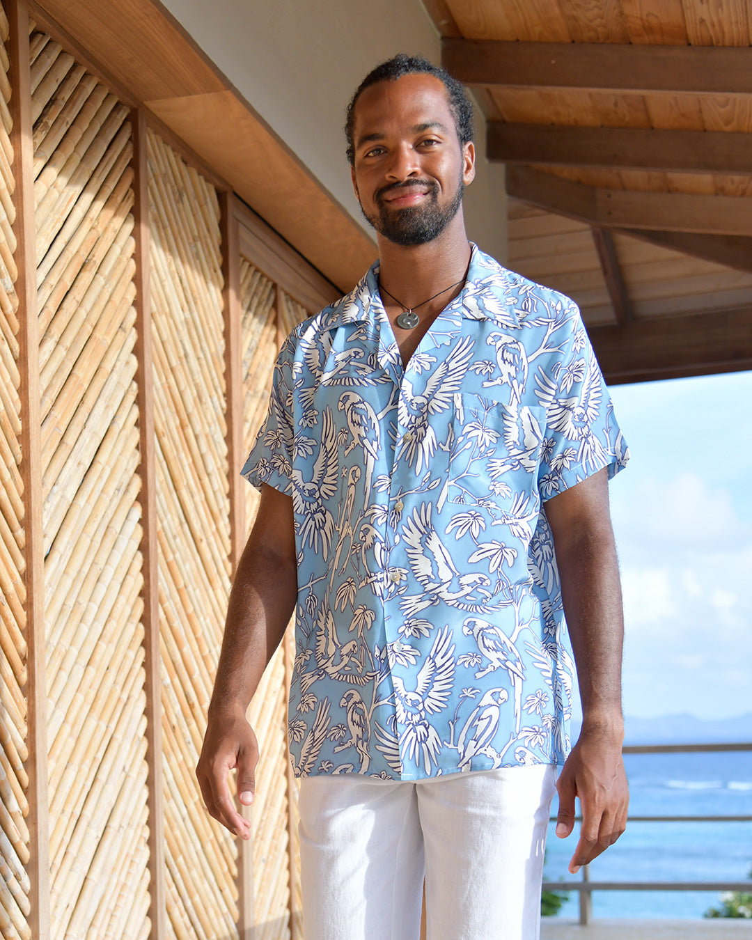 Men's Parrot Blue silk Festival Shirt styled with white linen trousers at Frenchman's Field Villa Mustique