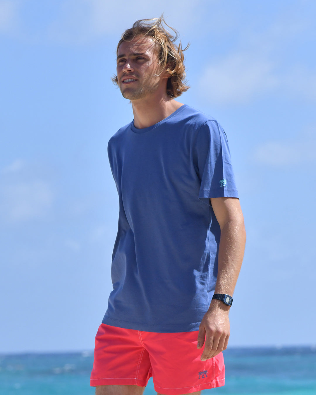 Pink House navy T-shirt paired with faded red swim shorts worn on Pasture Bay, Mustique Island