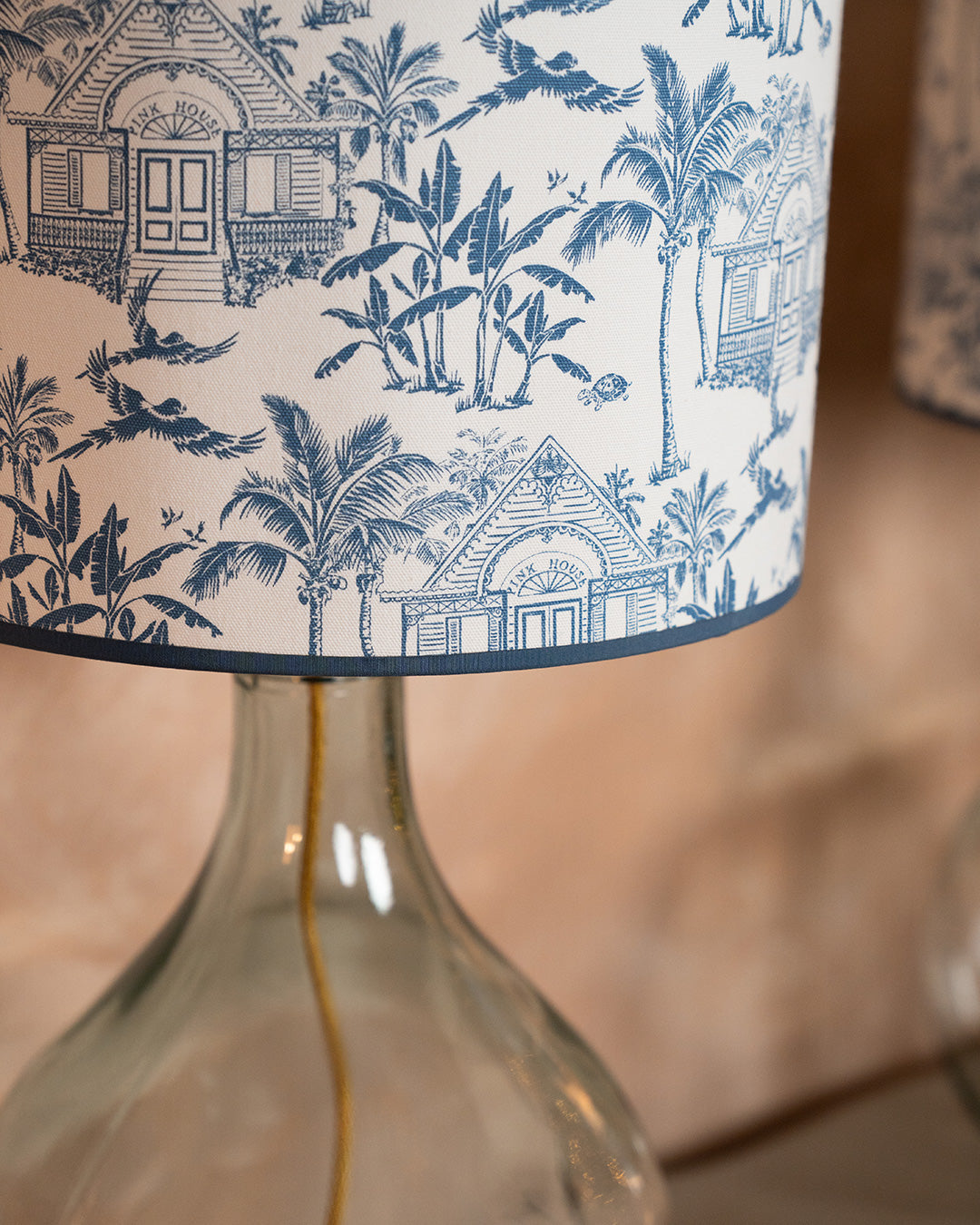 Pink House Toile blue cotton fabric used for a lampshade, featuring Pink House, palm trees and tropical island motifs