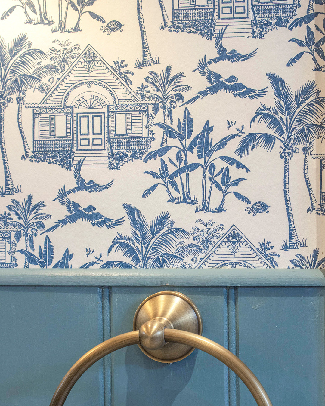 Pink House Toile Wallpaper in Semley Blue bathroom detail with tropical house, palms, parrots and turtles