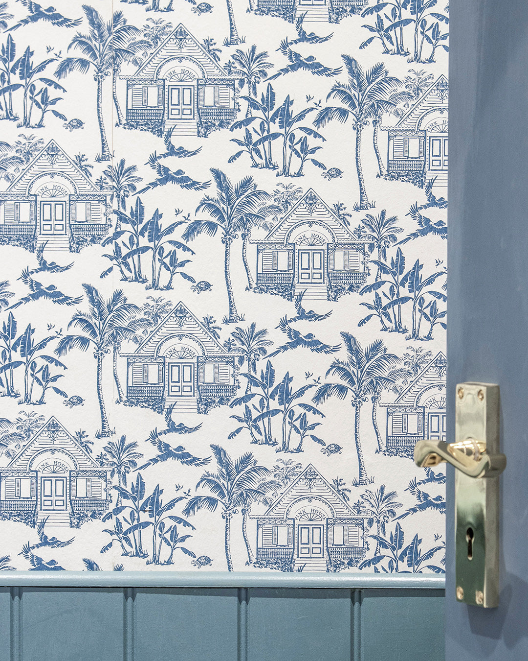 Semley Blue Pink House Toile Wallpaper featuring Caribbean houses, palm trees, parrots and turtles