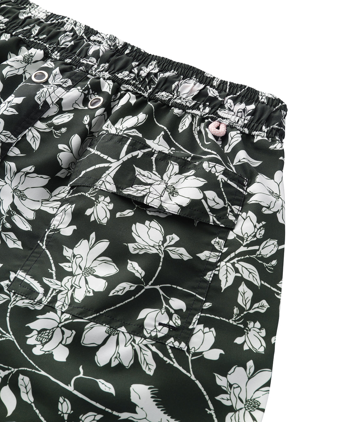 Close-up back pocket detail of Iguana print swim shorts in spruce green | Eco resort swimwear | Pink House Mustique