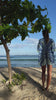 Lottie walks into the sea in unisex Banana Tree Blue silk festival shirt – luxury beachwear by Pink House Mustique on Mustique Island