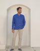 Model wearing dazzling blue collarless linen shirt with natural linen trousers, men’s resortwear by Pink House Mustique