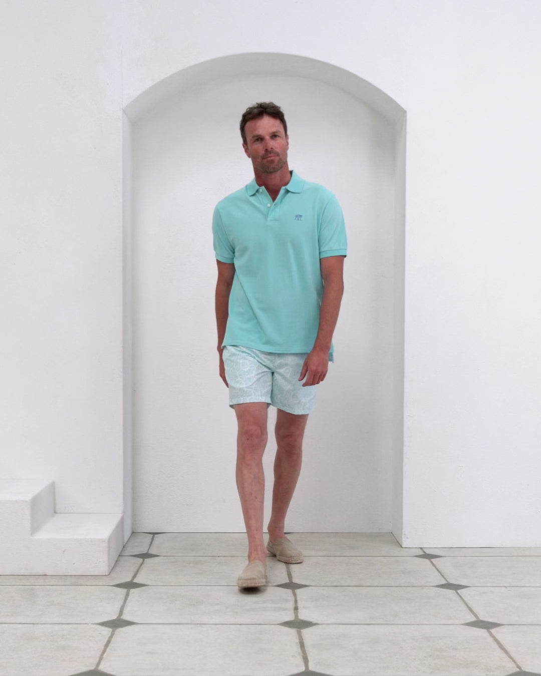 Men’s pale blue cotton polo with Coral Stone print swim shorts in recycled fabric, Pink House Mustique.