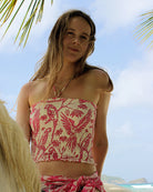 Model in silk crepe ruffle bandeau top in Parrot Pink at Lagoon Bay Mustique – strapless beachwear with island style