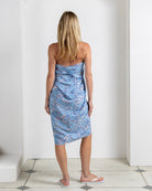 Back view of silk crepe de Chine sarong in Parrot Blue worn strapless as a beach dress – luxury resortwear by Lotty B