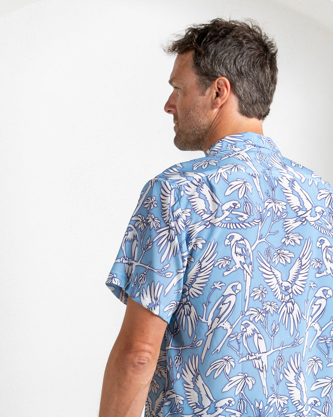 Back view of blue silk parrot print shirt for men – breathable summer fashion from Pink House Mustique