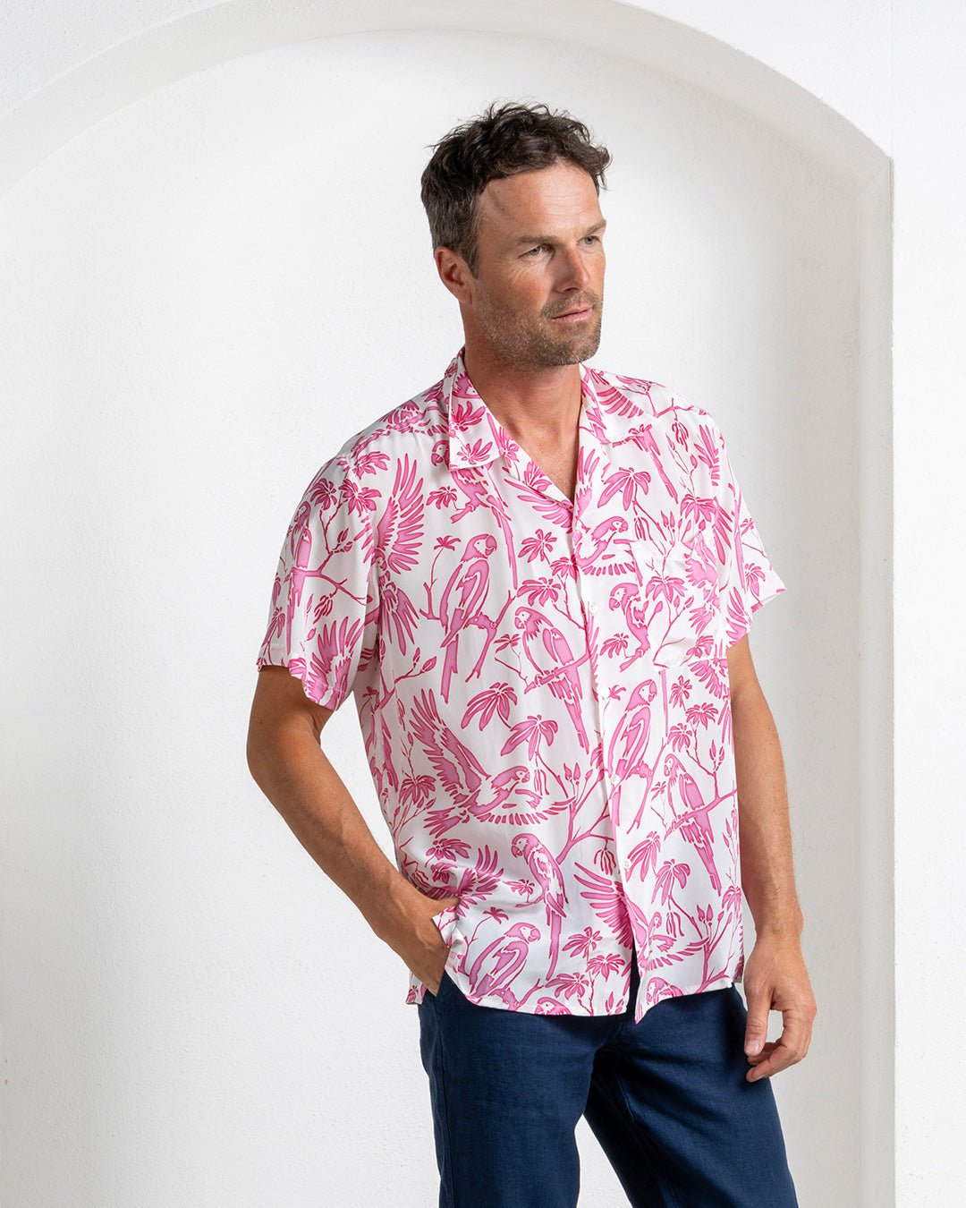Man in pink silk short sleeve shirt with white parrot print – tropical resort shirt by Pink House Mustique