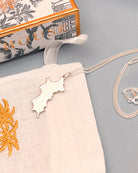 Close up hallmarked sterling silver Mustique island pendant necklace with Pink House Mustique packaging