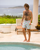 Man wearing Watermelon print men's swim shorts poolside at a villa on Mustique