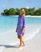 Luxury women’s Iguana Blue and Pink Decima linen dress by Pink House Mustique, modeled on Lagoon Beach.