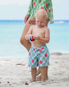 Little boy wearing Watermelon print boys' swim shorts on a Caribbean beach