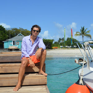 Mens orange swim shorts worn with violet linen shirt by designer Lotty B for Pink House Mustique lifestyle surf shack